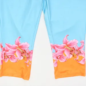 Close-up detail of high-waist pants with vibrant pink lily floral print and color block