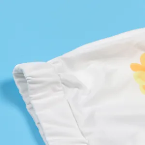 Detail view of white elastic waistband and yellow floral print on printed shorts set.
