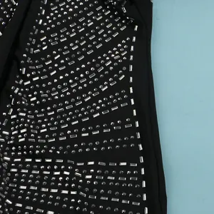 Primer plano detallado de patrones de pedrería plateada en un vestido negro sexy