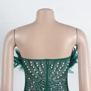 Detail eines grünen figurbetonten Kleides mit elegantem Perlen- und Strassbesatz am Rücken.