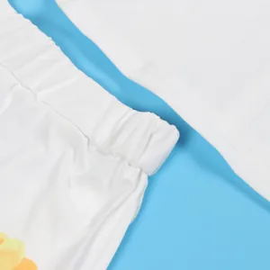 Detailed close-up of elastic waistband and soft white fabric on casual print shorts set