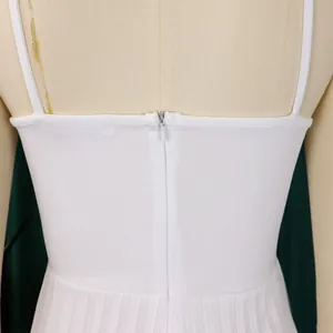 Close-up detail of the back hidden zipper and pleated fabric on a white elegant jumpsuit