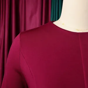 Gros plan sur l'encolure ronde et la texture du tissu d'une robe crayon bordeaux chic