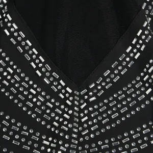 Primer plano de los detalles de pedrería en un sexy vestido negro de fiesta con cuello en V.