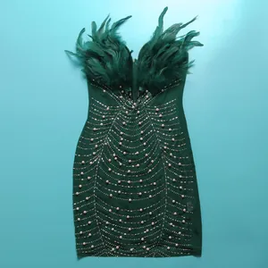 Nahaufnahme des Federbesatzes und der Perlenbestickung an diesem grünen Bodycon-Kleid