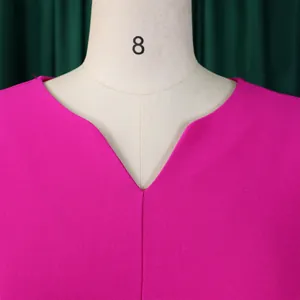 Détail en gros plan de l'encolure en V d'une élégante robe plissée magenta pour femmes