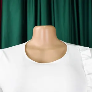 Détail d'une robe crayon blanche avec encolure ronde et volants à l'épaule