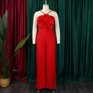 Detailed view of the elegant red pleated jumpsuit with a large 3D flower accent