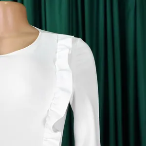 Détail de la manche à volants blanche sur une robe fourreau élégante