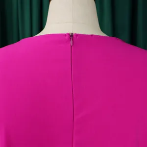 Gros plan de la fermeture éclair invisible au dos d'une robe plissée magenta de haute qualité