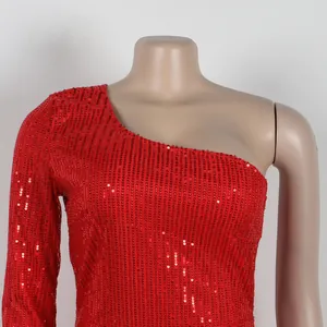 Close-up view of red shimmering sequin fabric on one-shoulder evening party dress