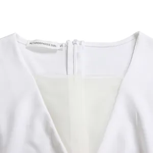 Macro view of white V-neck jumpsuit featuring transparent mesh panel and garment label