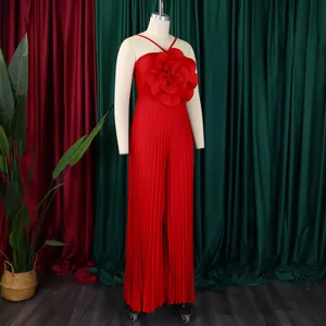 Detailed view of a red pleated jumpsuit featuring a large decorative 3D flower detail
