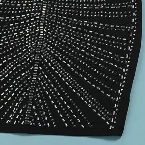 Vista detallada de patrones geométricos de pedrería en vestido negro sexy de gala
