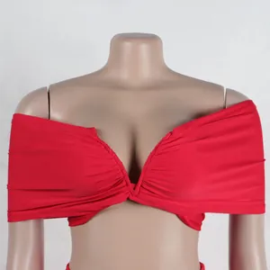 Detailed macro view of a vibrant red off-the-shoulder bandage crop top on a mannequin.
