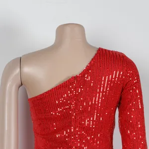 Close-up detail of red sequin one-shoulder dress with sparkling textured fabric finish