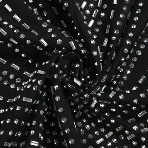 Vista macro de adornos de pedrería brillante en tela de vestido negro sexy