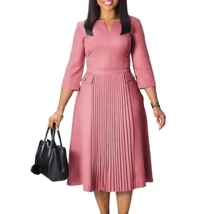 Vue détaillée d'une élégante robe midi rose à plis sur le devant et manches 3/4 chic.