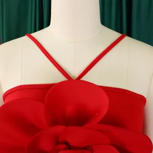 Close-up of large red flower applique on a stylish pleated jumpsuit bodice details.