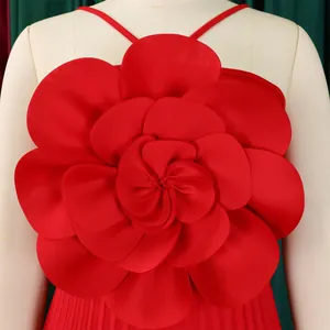 Macro detail of the oversized 3D red fabric flower decoration on an elegant pleated jumpsuit