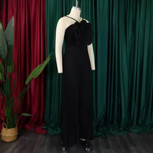Elegant black pleated jumpsuit with a 3D floral accent displayed on a mannequin