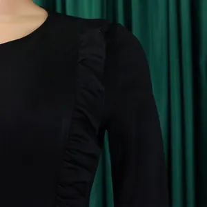 Détail rapproché d'une robe crayon noire avec d'élégants volants verticaux raffinés