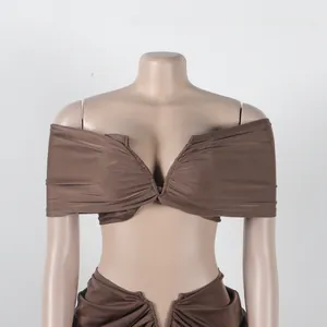 Detailed shot of brown two-piece set with off-shoulder pleated top and maxi skirt