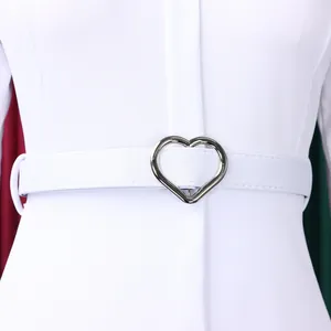 Vue détaillée d'une boucle en forme de cœur argentée sur une ceinture blanche.