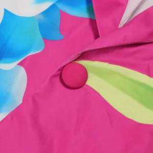 Close-up detail of vibrant floral print suit with fabric covered button fastening