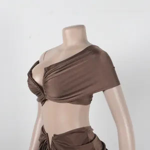 Close-up detail of the ruched texture and draped design on the brown bodycon two-piece set.