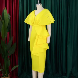 Elegant yellow V-neck evening dress with ruffle details and beaded shoulders on mannequin.