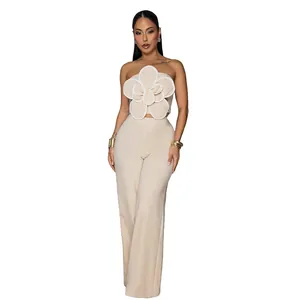 Gros plan sur un élégant ensemble beige deux pièces avec bustier fleur 3D et pantalon.