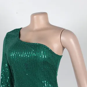 Detailed macro view of a dark green shimmering sequin one-shoulder evening dress on a mannequin