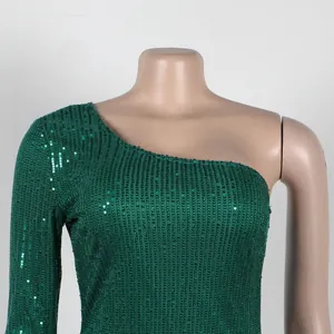 Detail shot of shimmering green sequined fabric on a one-shoulder evening gown