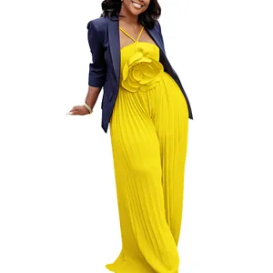 Elegant vibrant yellow pleated jumpsuit featuring a large 3D flower and navy blazer.