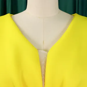 Close-up detail of a bright yellow sexy V-neck evening gown displayed on a mannequin