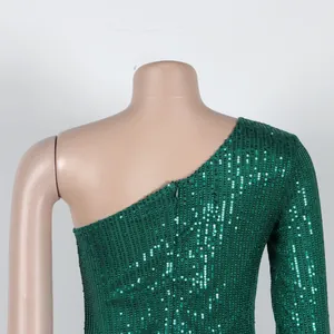 Close-up detail of the green sequin one-shoulder dress featuring a hidden back zipper.