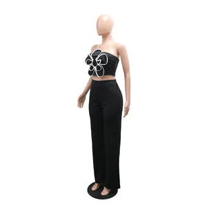 Vue détaillée de l'ensemble deux pièces noir avec haut tube fleur 3D et pantalon large