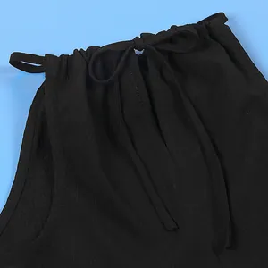 Close-up detail of sexy black halter neck tie and textured fabric on sleeveless top