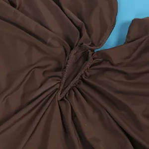 Macro view of brown ruched elastic fabric detailing on a sleeveless tight dress