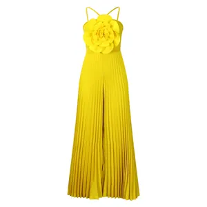Close-up of a vibrant yellow pleated sleeveless jumpsuit with a 3D floral chest detail