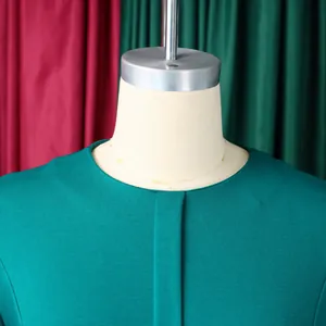 Gros plan sur l'encolure ronde élégante d'une robe crayon vert foncé pour femme d'affaires