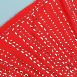 Primer plano de pedrería plateada brillante sobre tela roja de un vestido sexy de club