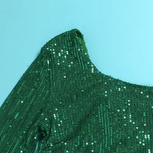 Detailed macro view of vibrant green sequined one-shoulder dress with intricate mesh splicing texture