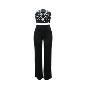 Ensemble deux pièces avec bustier à fleurs 3D et pantalon noir large à taille haute.