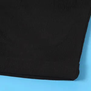 Macro detail shot showing the smooth texture and neat stitching of the black fabric hem.