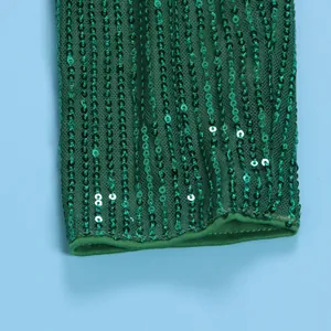 Detailed macro view of vibrant green sequins stitched onto mesh fabric for an elegant sleeve