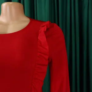 Détail d'une robe rouge ajustée montrant l'épaule à volants et la texture des manches longues
