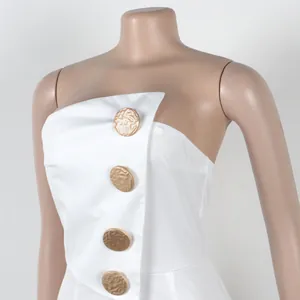 Detailansicht eines weißen trägerlosen Jumpsuits mit vier dekorativen Goldknöpfen.