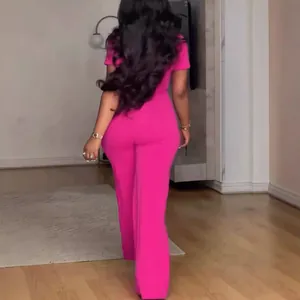 Vista posteriore che dettaglia il taglio e il colore vibrante di una tuta fucsia larga.
